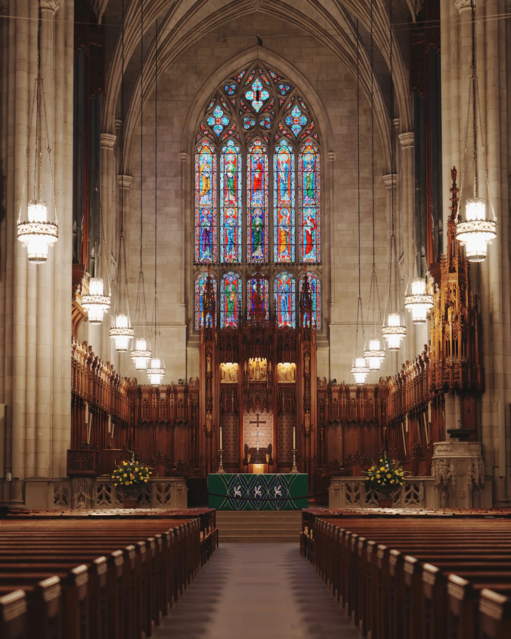 Wooden pews facing a stained glass window
